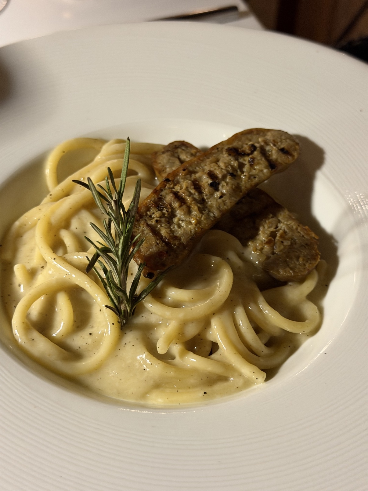 Bucatini Cacio e Pepe — with the grilled Italian sausage on top.